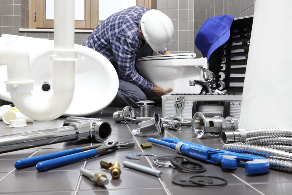 plumber at work in a bathroom, plumbing repair service, assemble and install concept